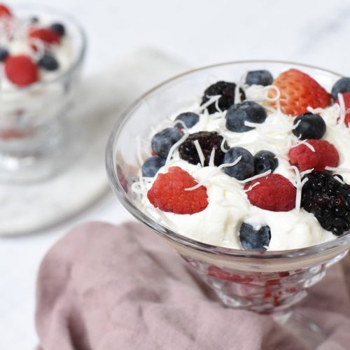 A berries with amaretto cream dessert with a purple napkin.