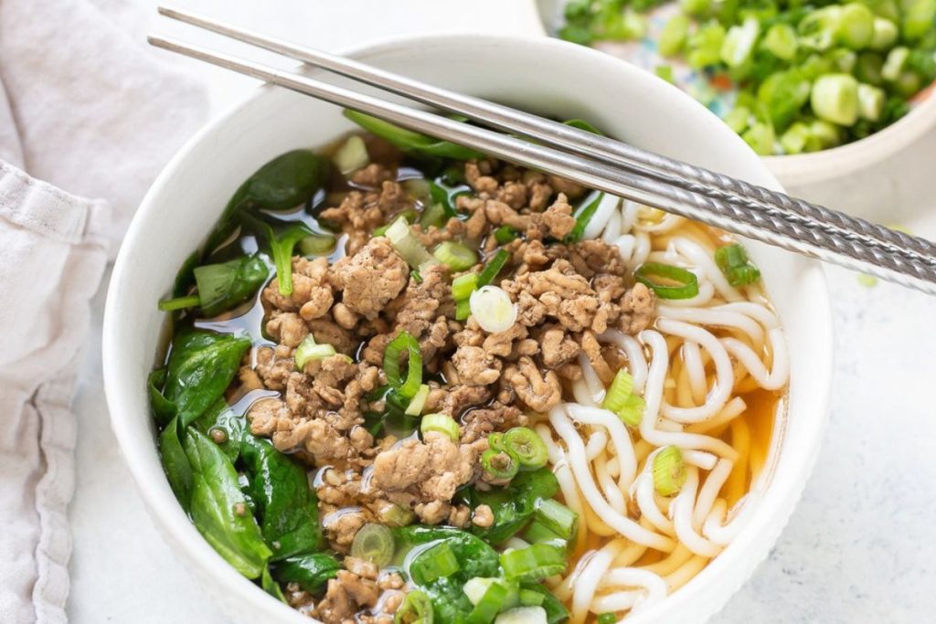 Pork and Spinach Noodle Soup in a white bowl.