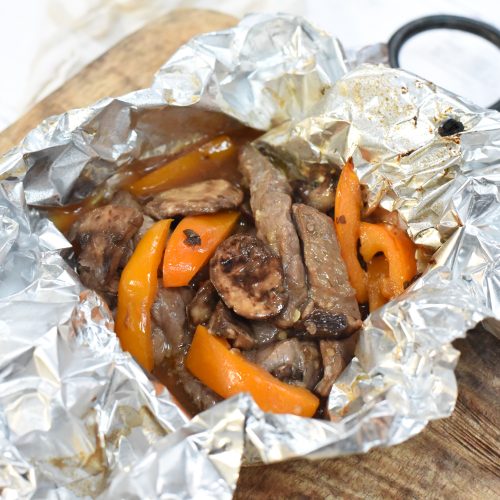 Marinated Steak and Mushroom Foil Packets on a cutting board.