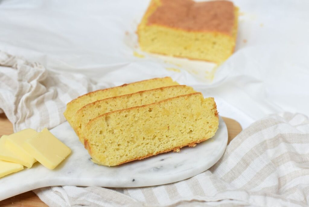 Keto honey bread, sliced on a cutting board.