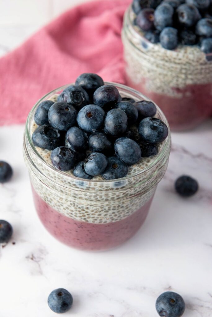 Layered blueberry chia pudding in a mason jars.