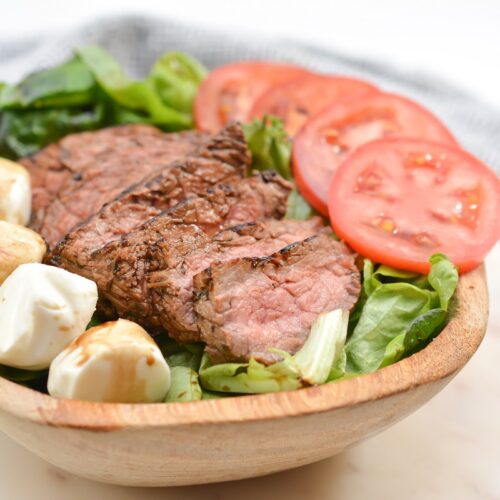 Steak Caprese Salad in a wooden bowl.